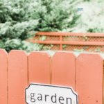 garden sign on red fence