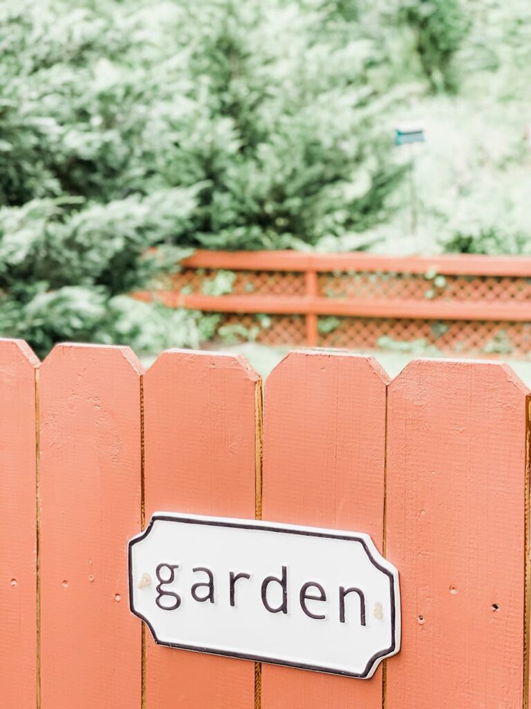 garden sign on red fence
