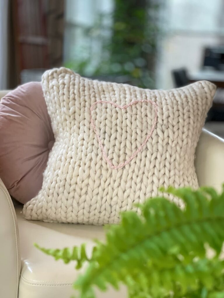 cream knit pillow with embroidered pink heart