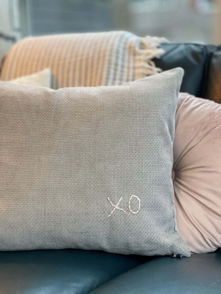 grey pillow with pink embroidered xo