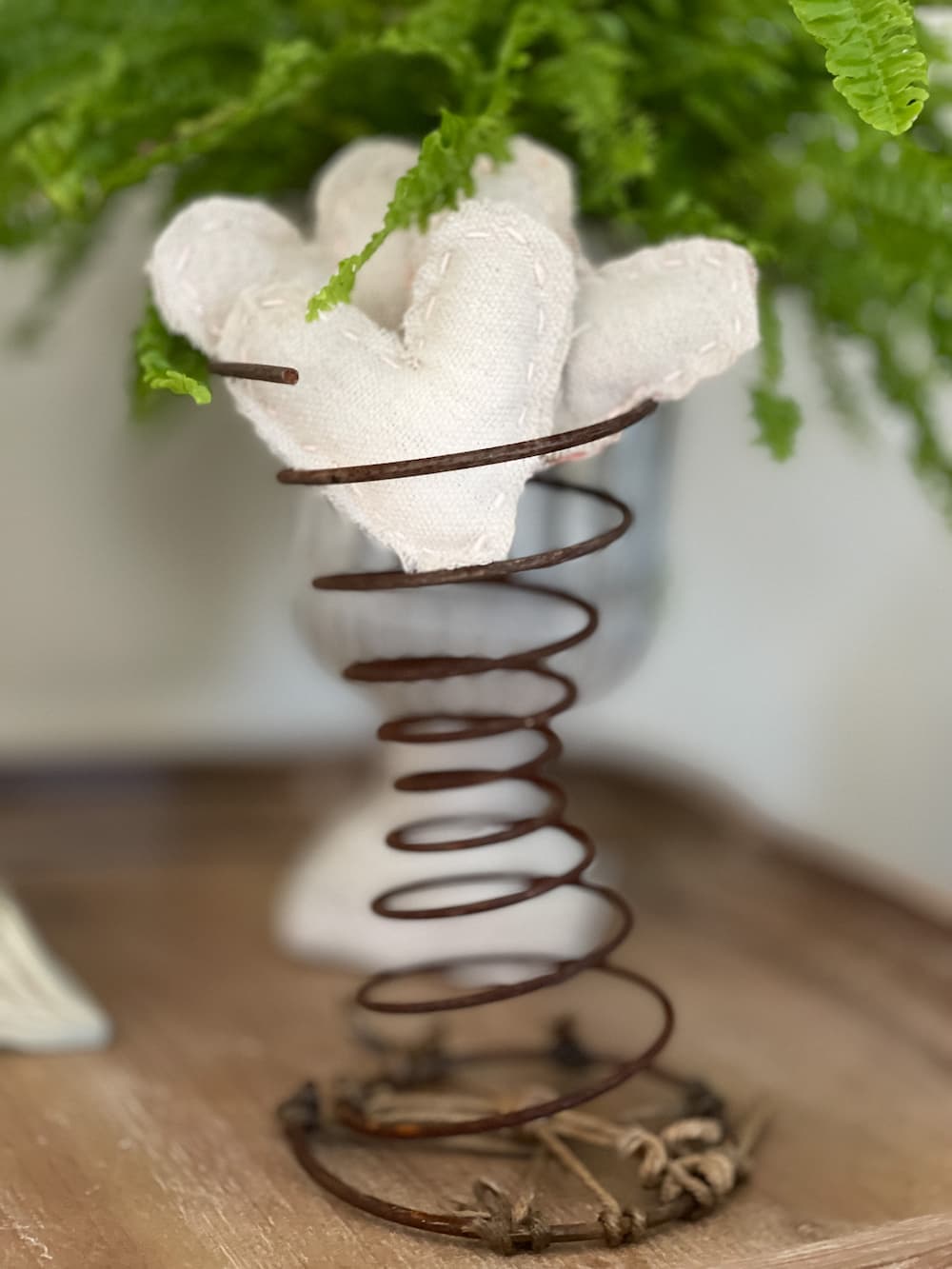 RUSTIC CLOTH HEART SITTING IN A VINTAGE BED SPRING