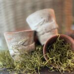 3 small vintage clay pots with clay bunny stamps on the outside.