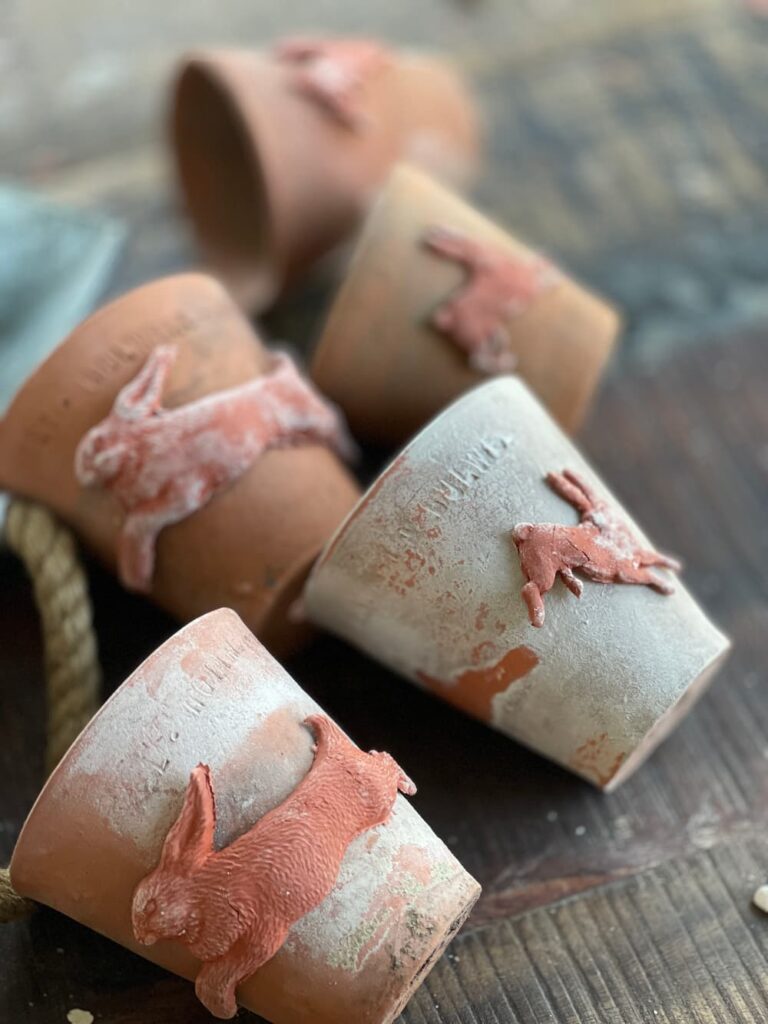 clay pots with clay bunnies drying on the pots while pots are laying on their sides