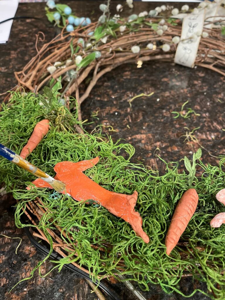 painting gloss on bunny on grapevine wreath