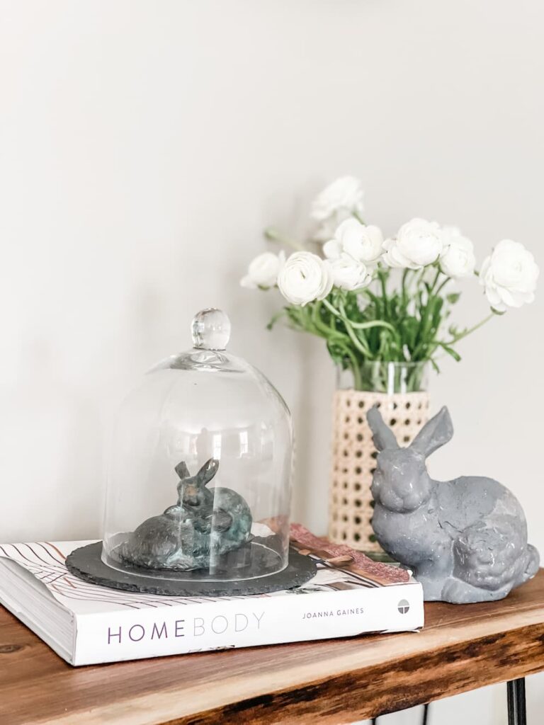 A VIGNETTE WITH A GLASS CLOCHE, A BOOK, A BUNNY AND MY THRIFTED VASE WITH CANE FILLED WITH WHITE FLOWERS