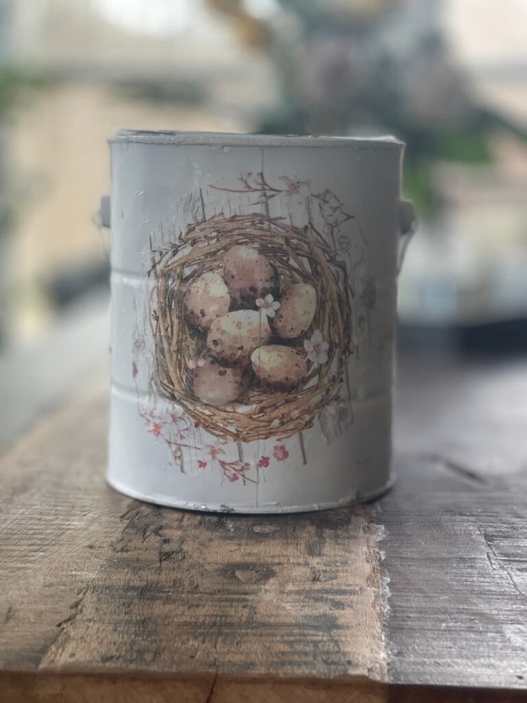 a large paint can with an image of a birds nest on it.