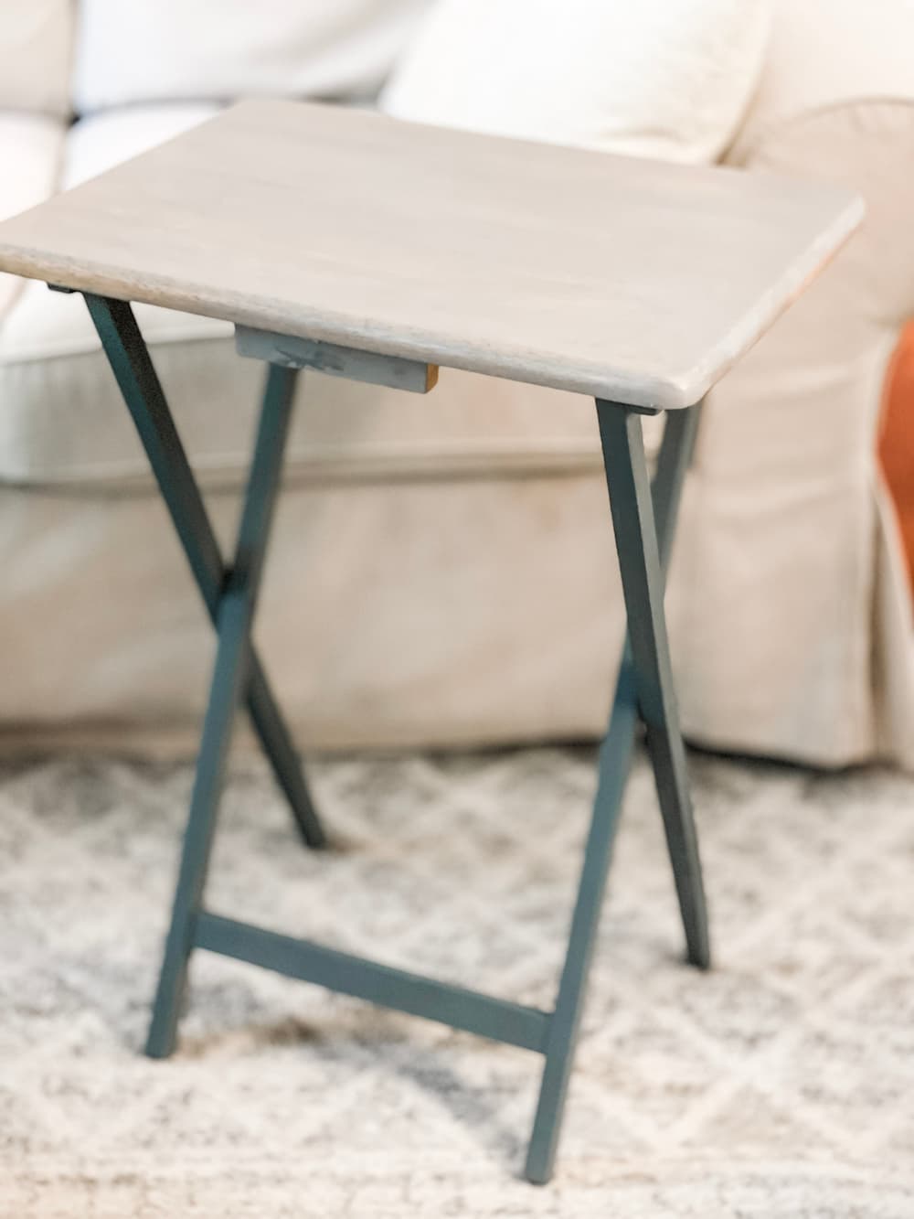 AN UPDATED WOODEN TV TRAY TABLE IN FRONT OF A SOFA PAINTED GREY