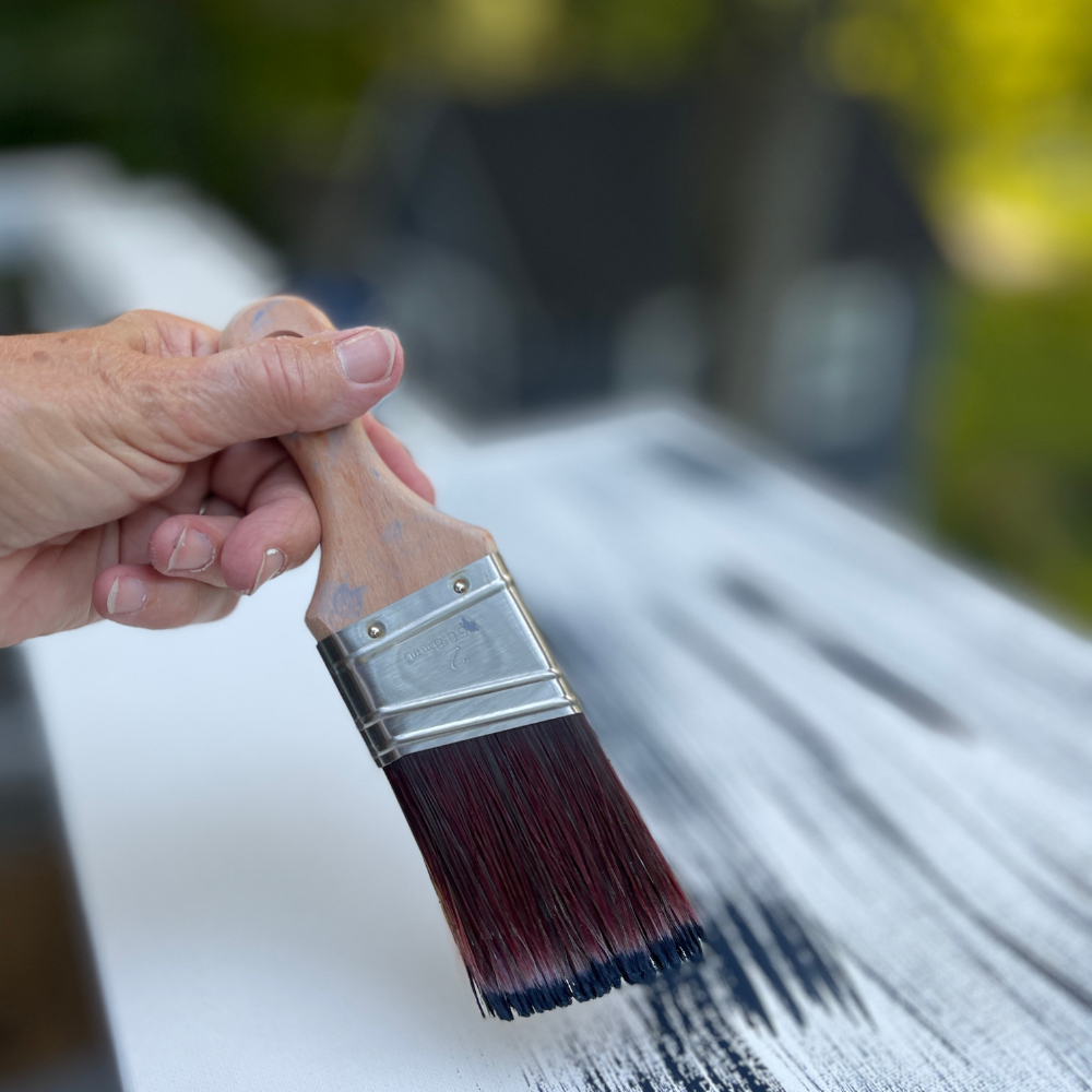 painting a blank canvas with navy paint