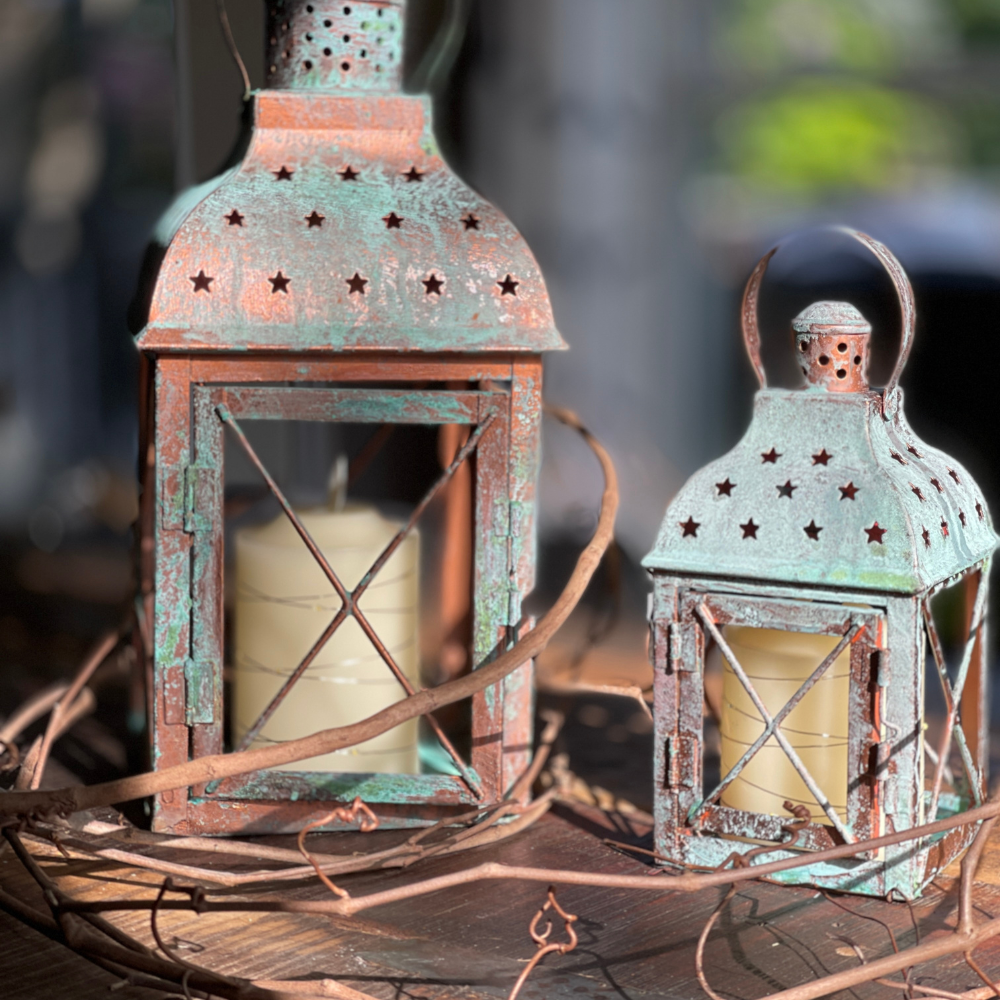 2 LANTERNS WITH A COPPER FINISH ON TABLE