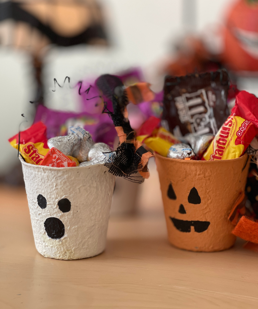 TWO PEAT POTS DECORATED AND FILLED WITH CANDY FOR HALLOWEEN